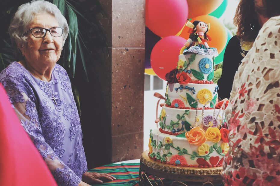 woman wearing purple floral long-sleeved dress besides 4-layer cake